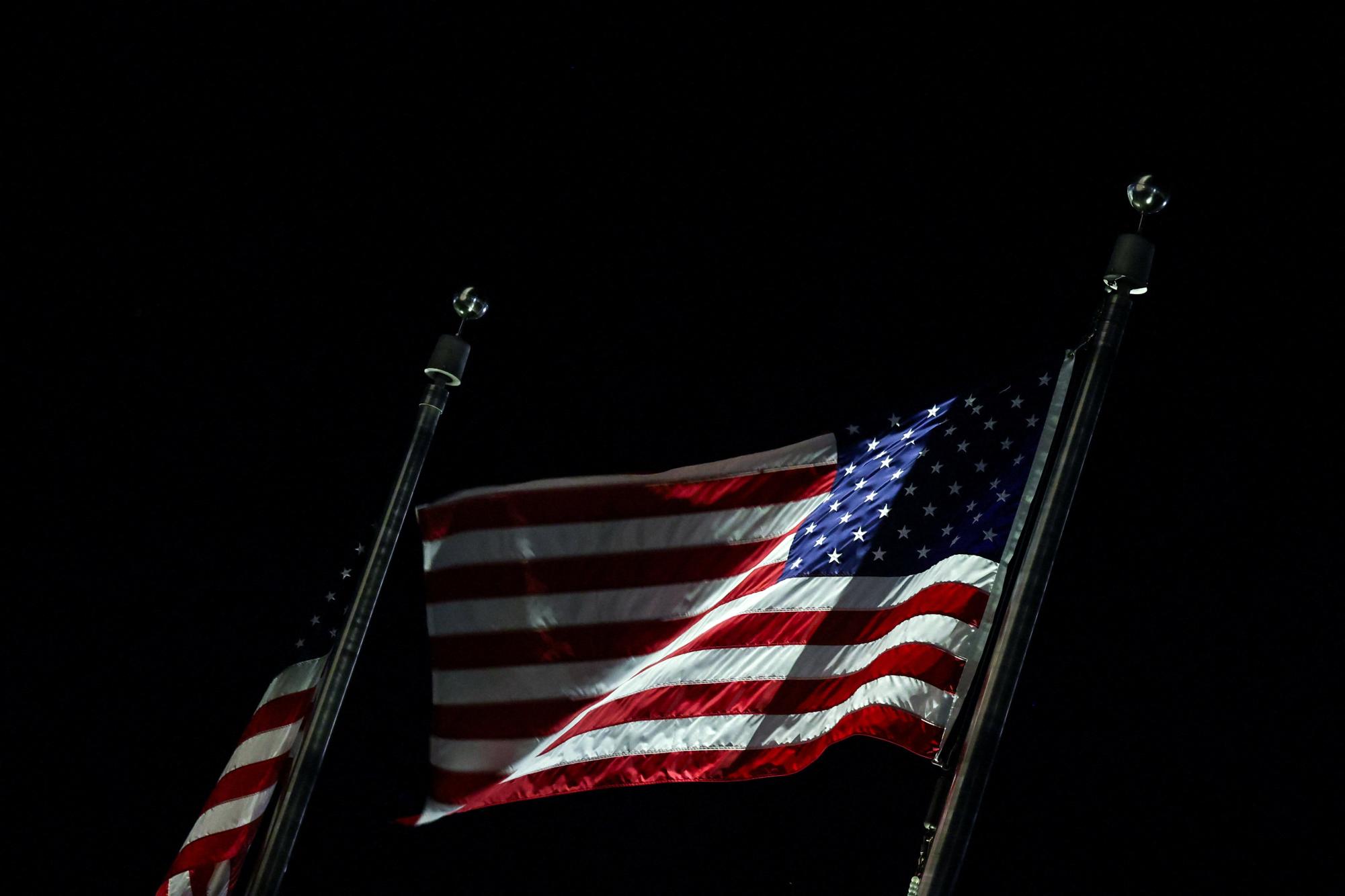American flags flutter at night in Washington, D.C., U.S., October 17, 2025. REUTERS/Kylie Cooper
